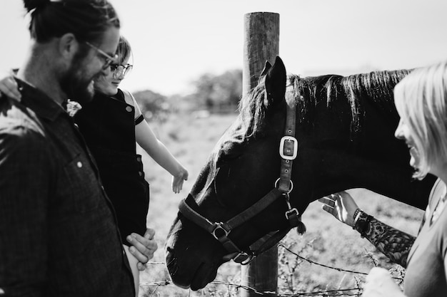 Young girl and family with a horse in the farm