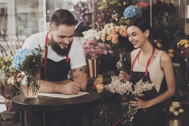 Young girl florist collects a bouquet of flowers