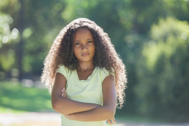 Young girl frowning at camera in the park