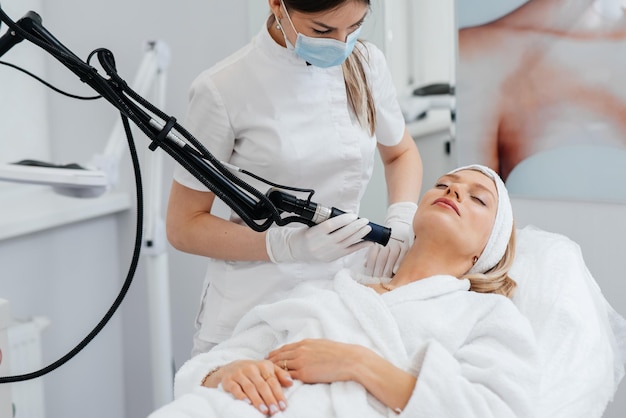 A young girl gets a carbon peeling for the skin of the neck in a beauty salon Laser pulses cleanse the skin Hardware cosmetology The process of photothermolysis warming the skin