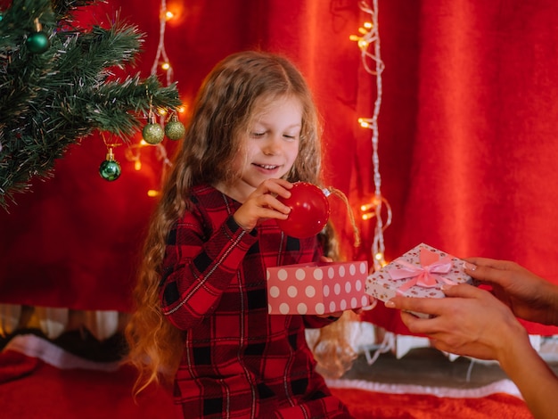 Young girl gets present from mother Christmas time at home