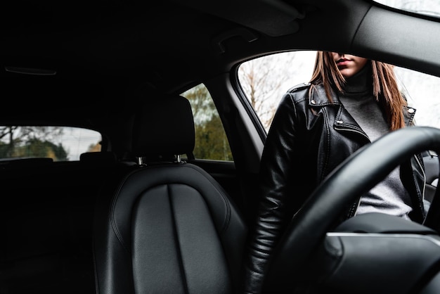 Young girl getting into a car on the road.