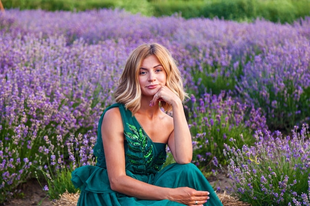 Young girl in green dress posing on lavender field