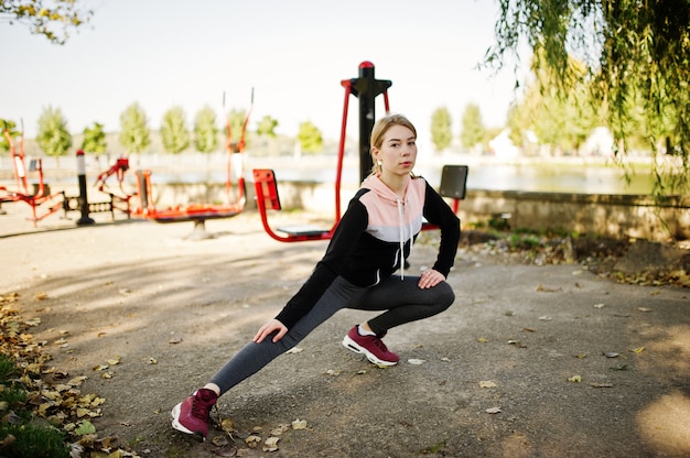 Young girl has the training and doing exercise outdoors on street simulators