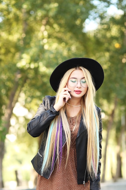 Young girl in hat using smartphone