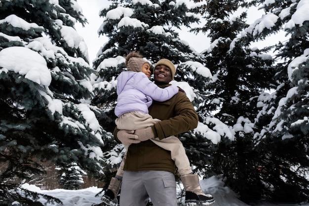 Young girl having fun with her father on a snowy winter day