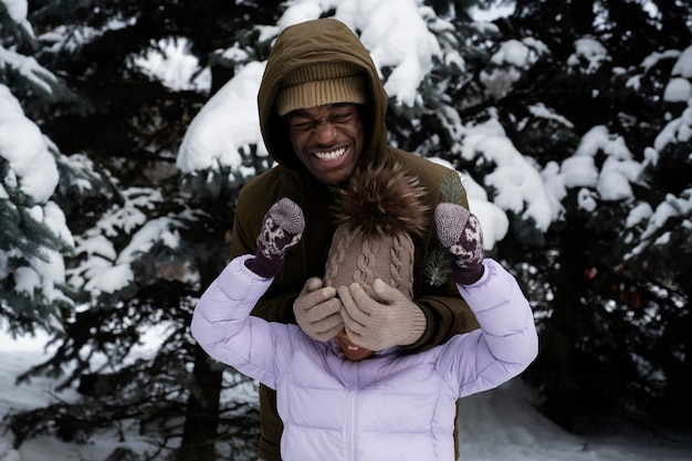 Young girl having fun with her father on a snowy winter day