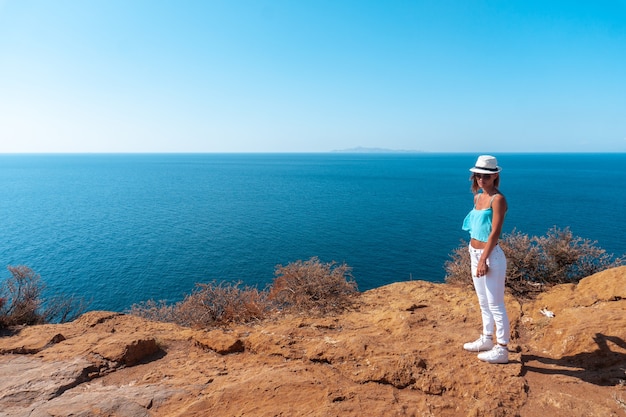 Young girl on a high cliff above the sea