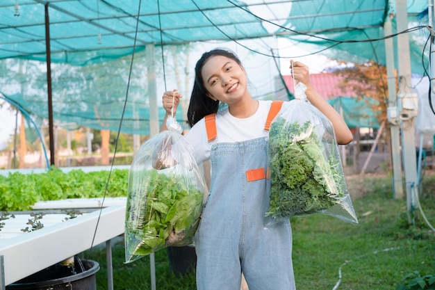 Young girl holding a large bag of vegetables at hydroponic farm