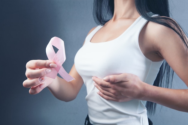 Young girl holding a pink ribbon