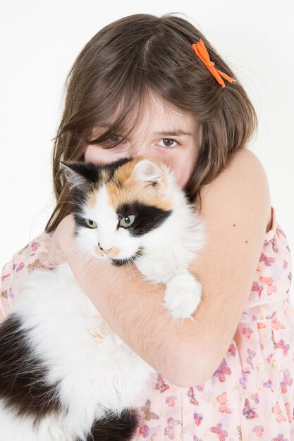 Young girl holds in her arms and hugs cat in White background