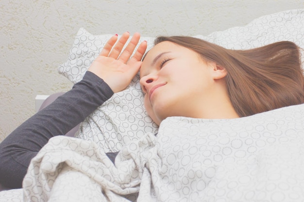 Young girl at home in bed lies sleeps