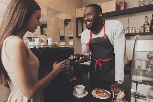 Young girl is calculated the cafe by credit card