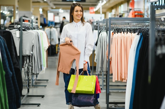 Young girl is choosing to buy clothes at the mall