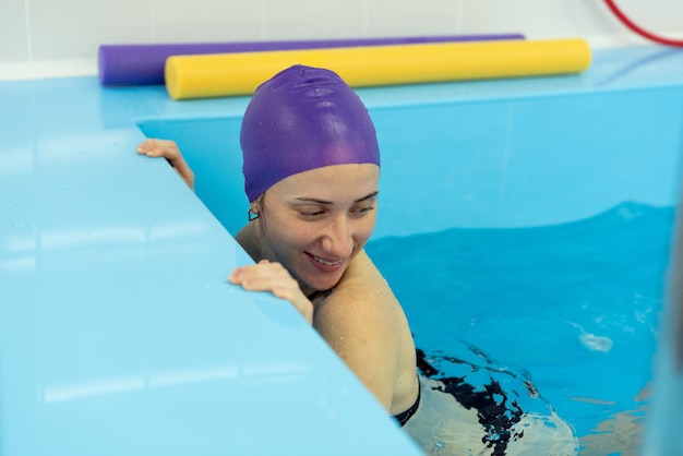 A young girl is engaged in aqua yoga in the pool Swimming for pregnant women Health concepts