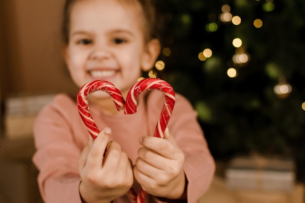 A young girl is holding a Christmas gift in her hands