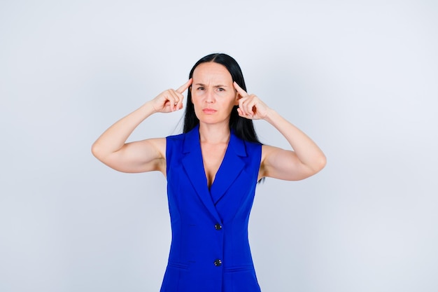 Young girl is thinking by holding forefinger on temples on white background