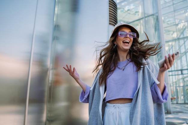 Young girl jumping with mobile phone in hand cool happy woman have a fun high quality photo