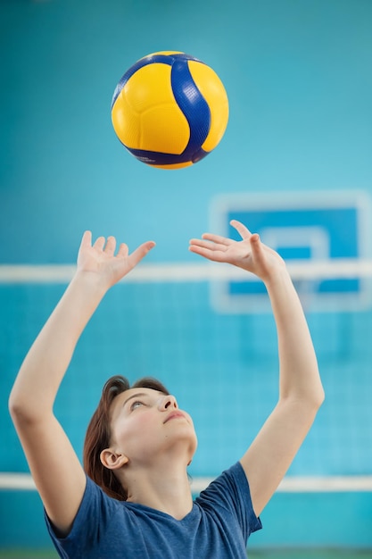 Young girl learning fundamental skills to play volleyball Photo in action of a girl training to pass and set the volleyball