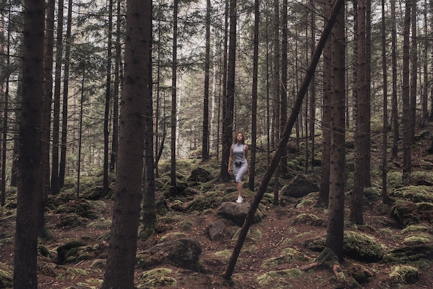 Young girl in a long dress standing in the woods