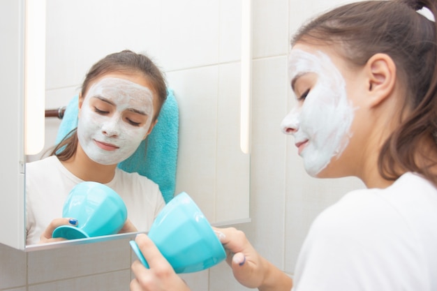 Young girl makes a moisturizing cleansing face mask