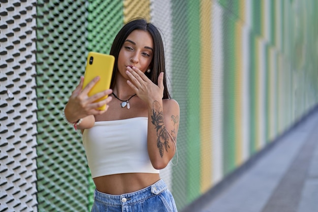 Young girl making a video call sending a kiss