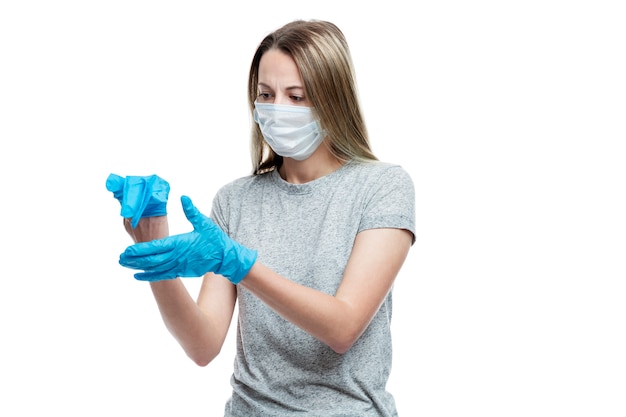 A young girl in a medical mask wears blue latex gloves. Precautions and protection. . Space for text.