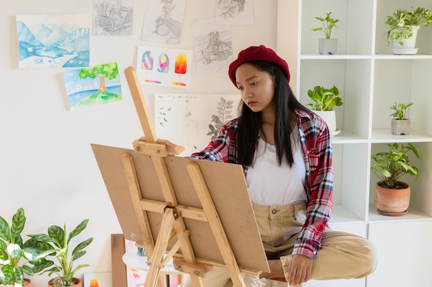 Young girl painting on paper at home wood frameHobby and art study at home