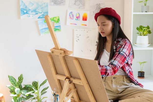 Young girl painting on paper at home wood frameHobby and art study at home