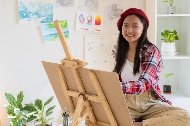 Young girl painting on paper at home wood frameHobby and art study at home