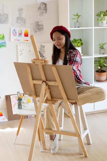 Young girl painting on paper at home wood frameHobby and art study at home