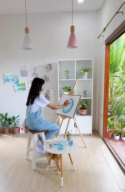 Young girl painting on paper at home wood frameHobby and art study at home