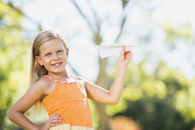 Young girl playing with a paper plane