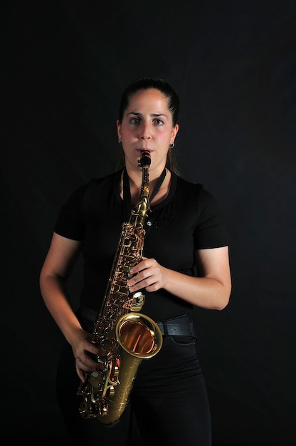 Young girl plays jazz music on saxophone