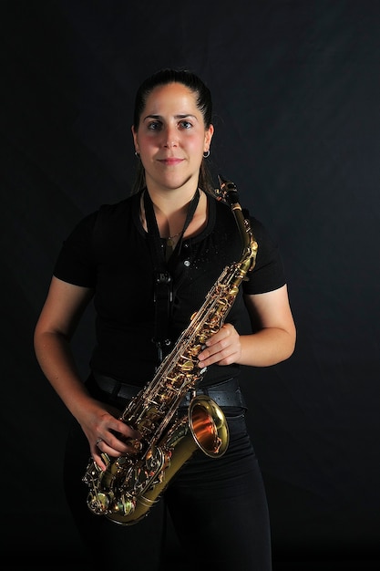 Young girl plays jazz music on saxophone