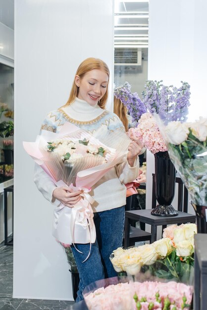 A young girl poses with a beautiful festive bouquet against the background of a cozy flower shop Floristry and bouquet making in a flower shop Small business