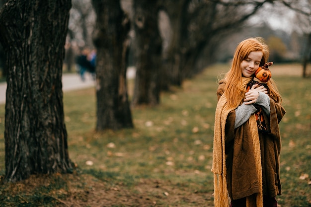 Young girl posing in the park hugging toy