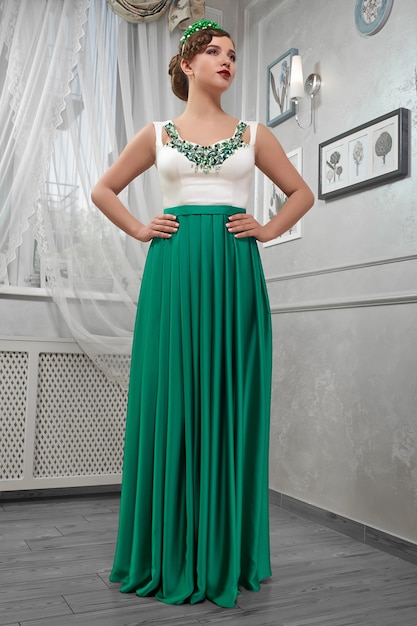 Young girl posing in white and green evening long dress.