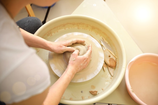 A young girl potter is teaching a master class on the creation of ceramic products from clay. close-up.