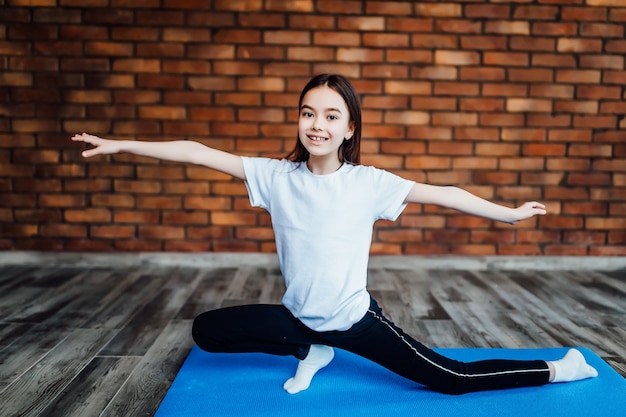 Young girl practicing yoga, stretching exercise, Extended side angle pose.. Trikonasana.