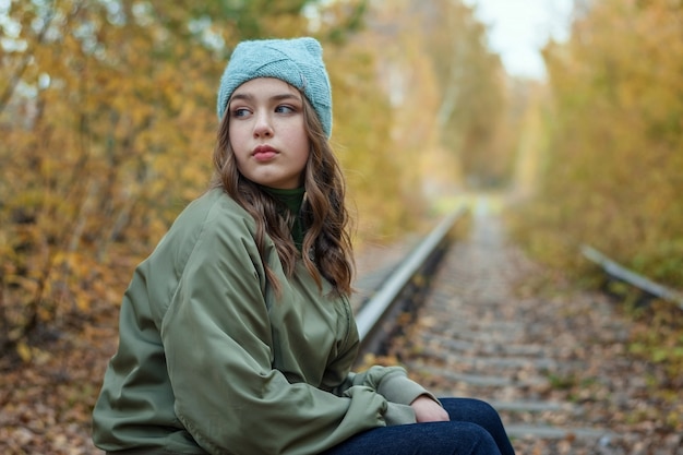 Young girl on the railroad tracks in autumn