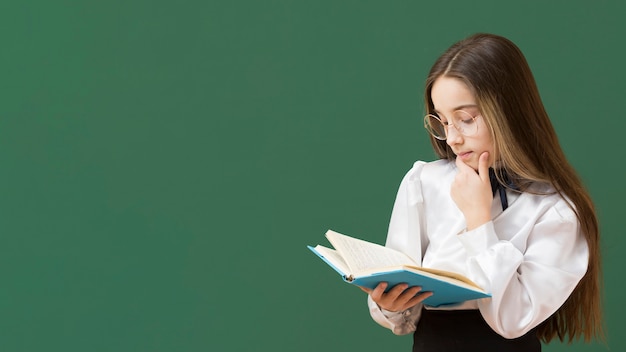 Young girl reading book copy space