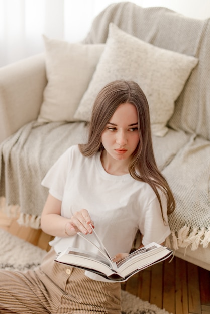 Young girl reading book at home