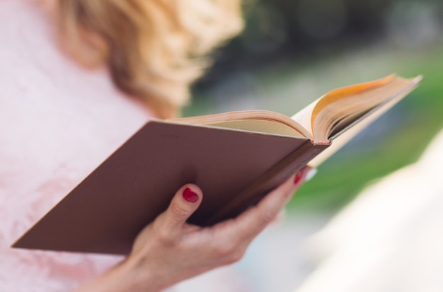 Young girl reading a book in the Park.