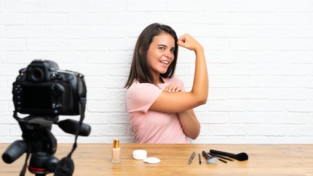 Young girl recording a video tutorial making strong gesture