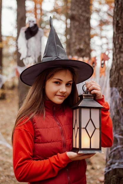 Young girl in red clothes and witch hat with a smile on her face