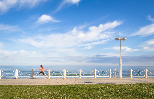 Young girl running in beach promenade on summer