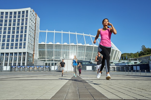 Young girl running in front of other sportsmen