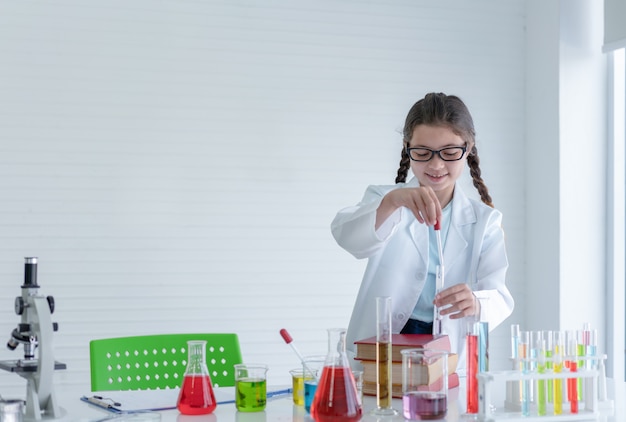 Young girl scientist making experiments chemical in glass tube in the laboratory room