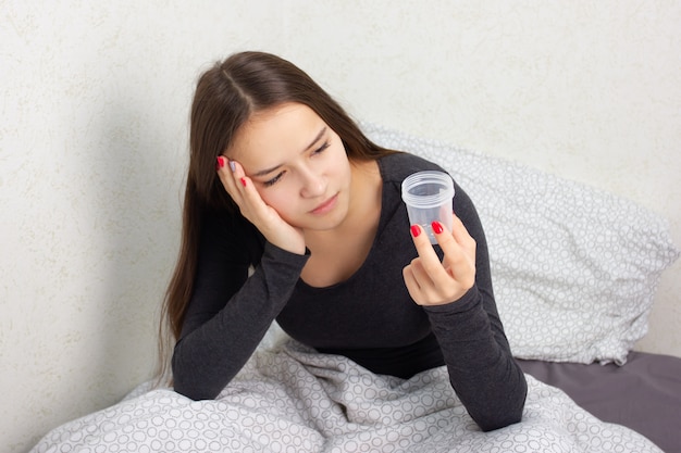 Young girl sits on a bed with a bank for analysis